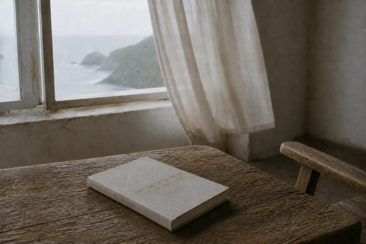 La portada de Twenty-Two Rooms sobre una mesa de madera gastada, junto a una ventana abierta al mar.